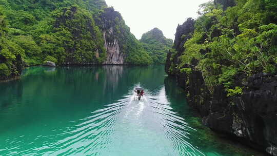 空中跟随拍摄的旅游快艇在蓝色泻湖的巴拉望菲律宾