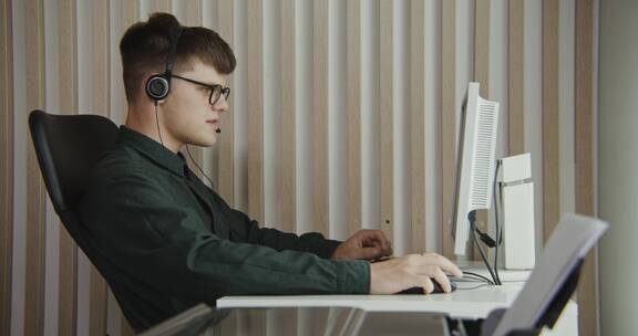 男人戴着耳机玩电脑