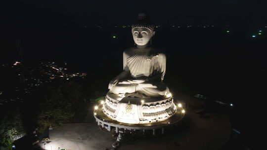 泰国普吉岛山上的夜间流逝白佛和海岸附近城