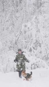 女人在雪地里和小狗玩耍