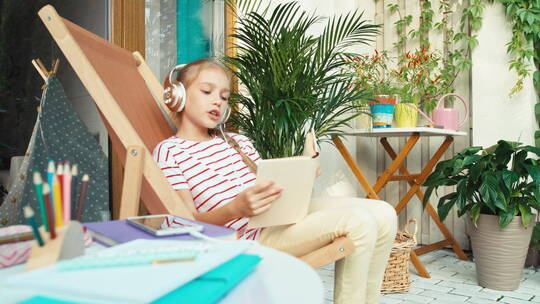 女孩坐在躺椅上听音乐