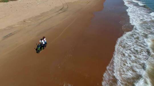 航拍在海边驾驶摩托车的人们