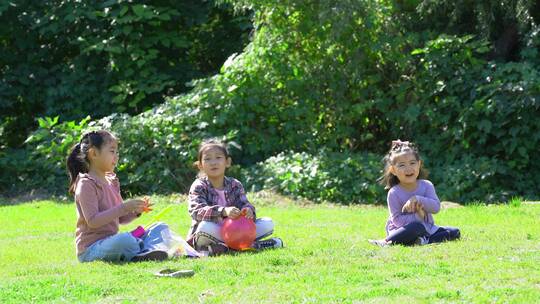 秋天午后两个坐在草坪上玩气球的女孩视频素材模板下载