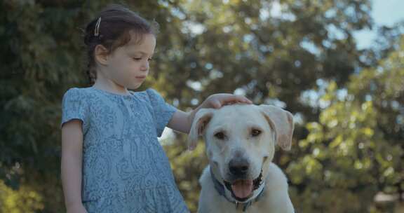 小女孩抱着她的狗，在花园里掐死了他的脖子