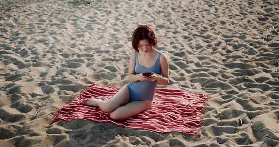穿着泳衣的女人在海滩玩电子游戏