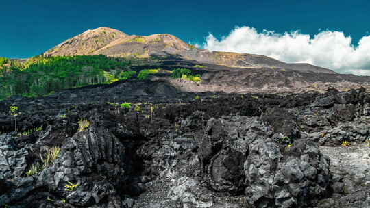 印度尼西亚巴厘岛巴图尔火山黑色熔岩的戏剧性景象。延时