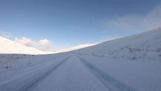 驾车穿过白雪覆盖的道路