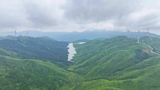 绿色山坡上矗立着的风力发电机群