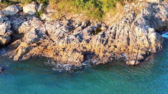 空中俯瞰岩石海岸边的碧绿海水