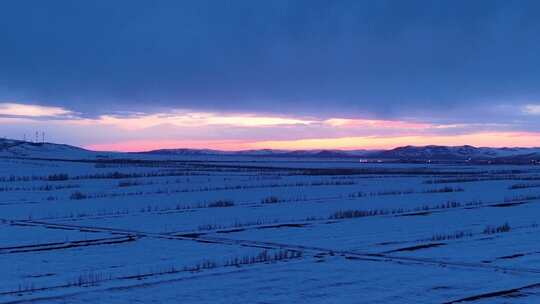 航拍浓郁夕阳下的垦区雪原