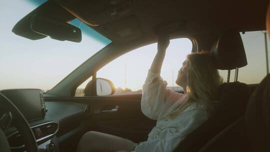 一个坐在副驾驶向外看风景的女人