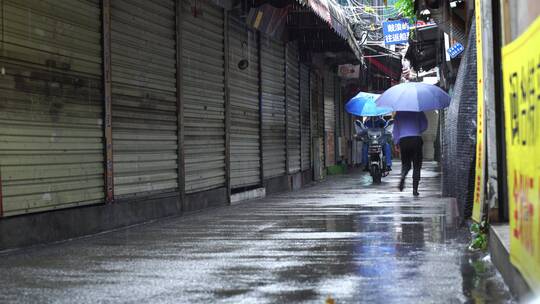 下雨天巷子街道行人电动车