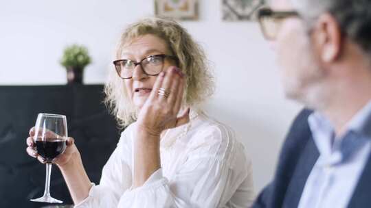 女人拿着酒杯说话