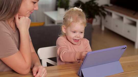 一个植入人工耳蜗的孩子和他的母亲一起玩平板电脑
