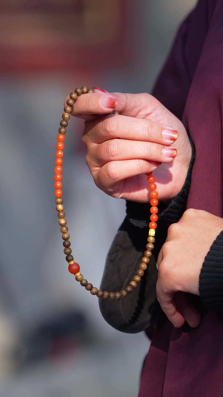 手持佛珠的手部特写