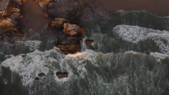 海浪拍打着布满巨石的海岸