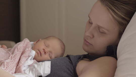 母亲和新生的女儿在白天睡在一起视频素材模板下载