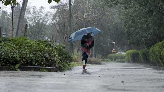 女孩撑着雨伞在街上蹦蹦跳跳