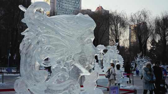 户外冰雕旁穿着冬装的行人冰灯游园会冰雪游