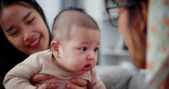 两个女人在家里客厅的沙发上开心地和一个小