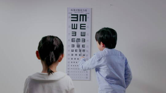 小男孩给小女孩测视力