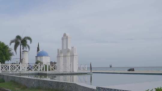 海边白色建筑景观，水面倒映宁静景象