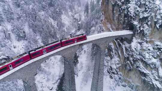 航拍雪中列车在桥隧上行驶