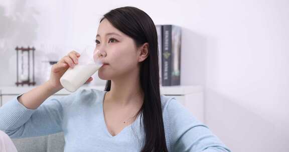 一个年轻女性在家喝牛奶