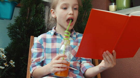 女孩喝着果汁看书