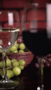 装有红葡萄酒和白葡萄酒的玻璃杯_放着葡萄