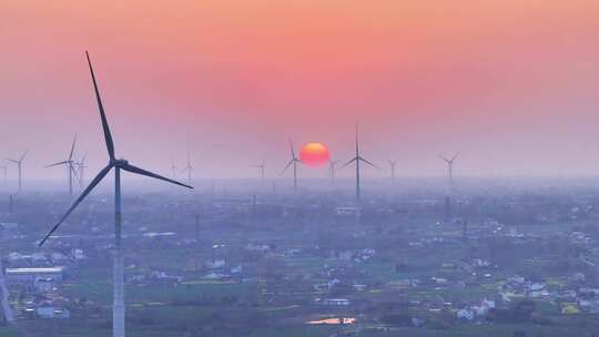 航拍夕阳落日太阳风力发电站群村庄农户平原