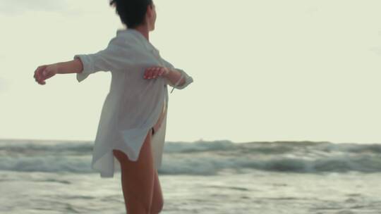 美女在海边沙滩漫步跳舞
