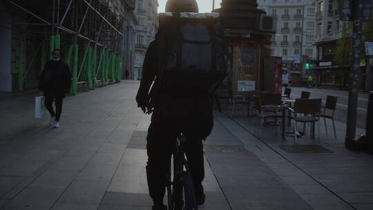在街边骑自行车的背包客视频素材模板下载