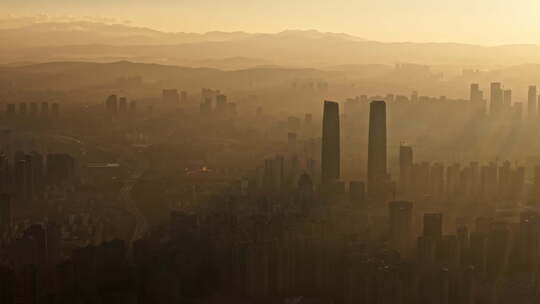 日出时金色光影中的昆明城市高楼