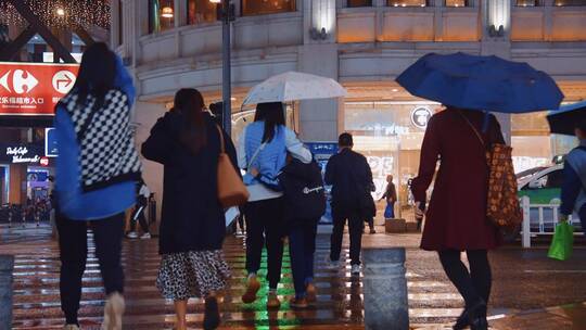 雨天城市夜晚路口斑马线行人过马路