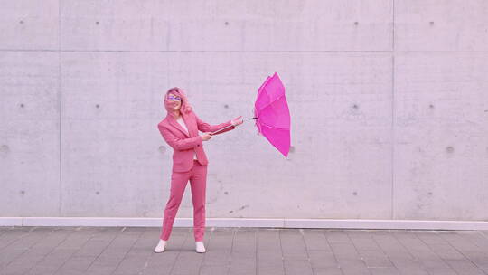 暴风雨天气里打伞的粉色女人