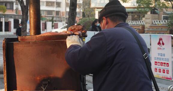 街头小摊老人卖烤红薯温暖逆光剪影