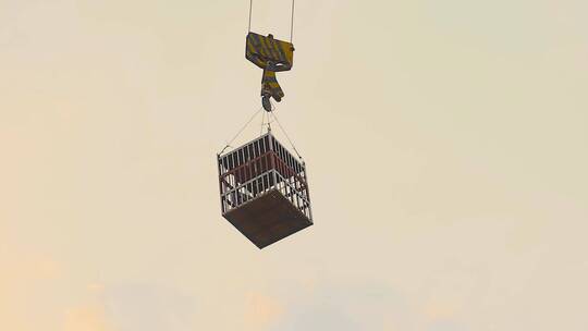 建设工地视频夕阳下塔吊吊装幕墙玻璃吊货