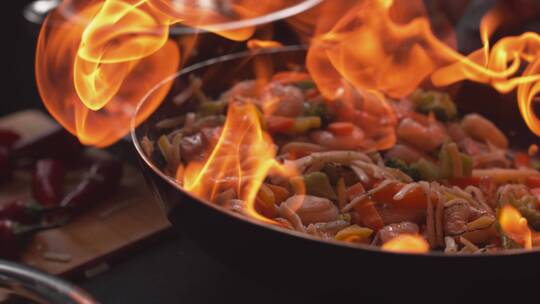 虾和蔬菜在有火的煎锅里