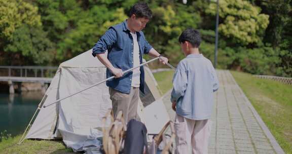 一对父子正在湖边扎帐篷 露营 踏青