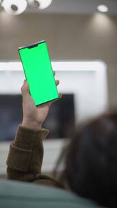 女性居家使用绿色屏幕绿屏抠像替换屏幕手机