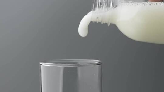 慢镜头拍摄瓶中牛奶饮品倒入玻璃杯