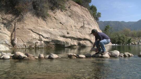 男子正在加利福尼亚州奥贾伊文图拉河保护区清除鱼栏上的石头