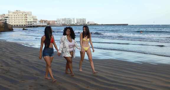 三名女性在海滩上开心地散步