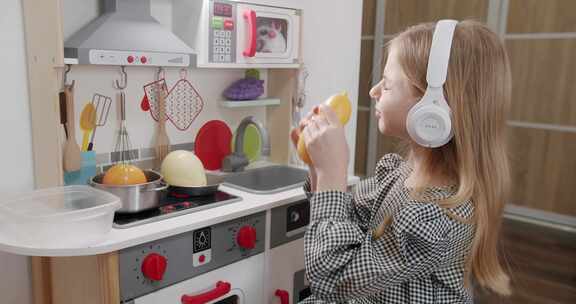 7岁的女孩戴着白色耳机在儿童房玩耍