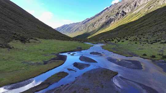 航拍四川甘孜乌库楚雪山下的草原溪流