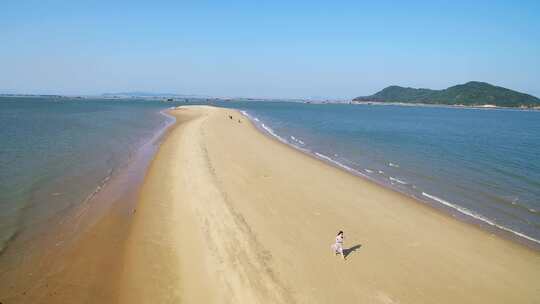 年轻女孩在漳州东山岛鱼骨沙洲漫步碧海蓝天