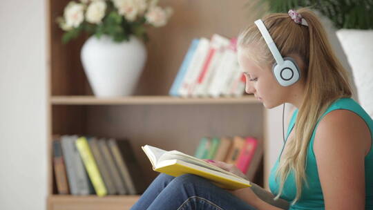 女孩戴着耳机听音乐看书