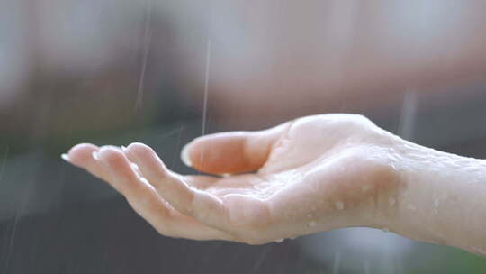 手伸向雨中触摸雨水特写