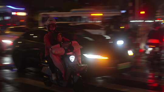 雨夜城市里骑电动车的人们